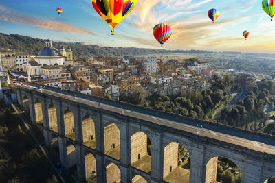 Aerial view at sunset of the ariccia bridge with hot air balloons