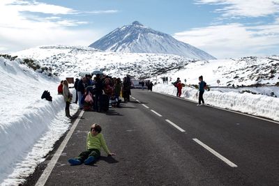 People on snowcapped mountain against sky