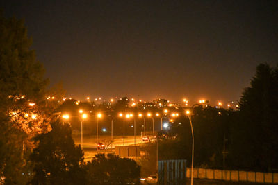 Illuminated buildings against sky at night