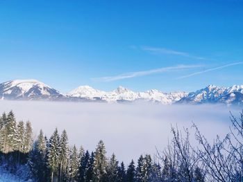 Scenic view of snowcapped mountains against blue sky