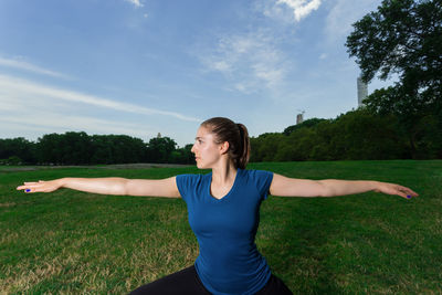Full length of woman with arms raised against sky