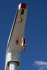 Low angle view of electric lamp against clear blue sky