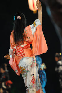 Rear view of woman wearing kimono while dancing 