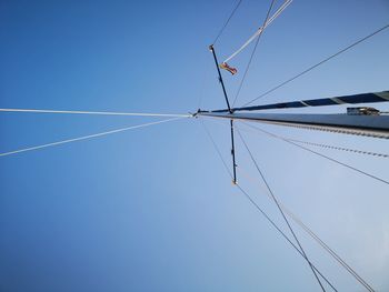 Low angle view of cables against clear blue sky