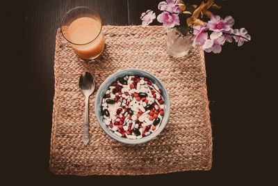 High angle view of bowl full of pills with glass of juice