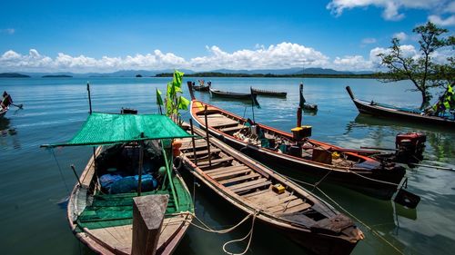 Panoramic view of boats moored in sea against sky