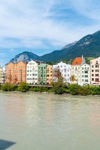 Buildings by sea against sky