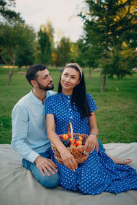 Full length of young couple sitting on table