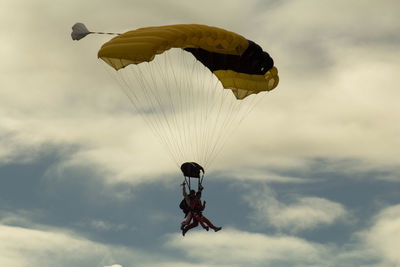 Low angle view of person paragliding against sky