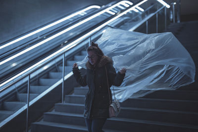 Young woman holding plastic on steps