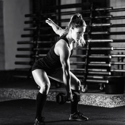 Cross training. young woman exercising with dumbbells