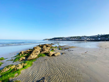 Scenic view of beach against clear blue sky