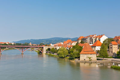 Arch bridge over river against buildings