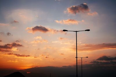 Low angle view of street light against cloudy sky