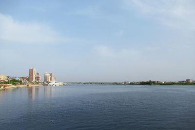 View of buildings by sea against sky