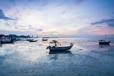 Boats moored on sea against sky