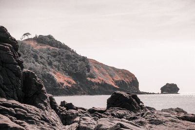 Scenic view of rocky mountains and sea against sky