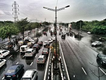 Cars on road against cloudy sky