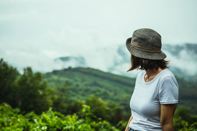 Side view of woman standing against sky