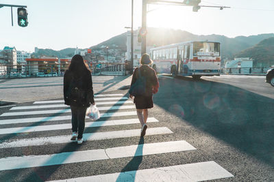 Rear view of women walking on road