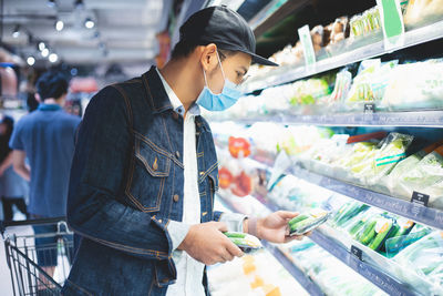 Man checking food while shopping at supermarket