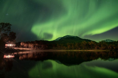 View of lake against northern lights at night