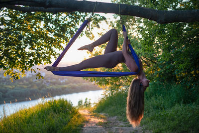 Low angle view of woman sitting on tree