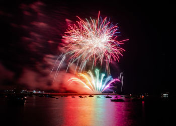 Firework display over river at night