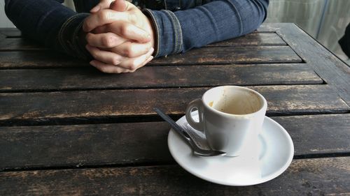 Close-up of man sitting with coffee on table
