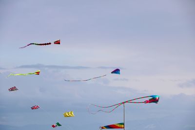 Low angle view of kites flying against sky