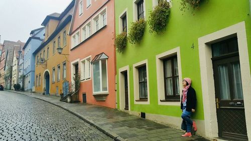 Woman walking on street amidst buildings