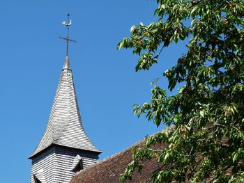 Low angle view of trees and building against sky