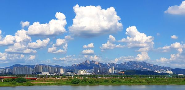 Panoramic view of city buildings against cloudy sky