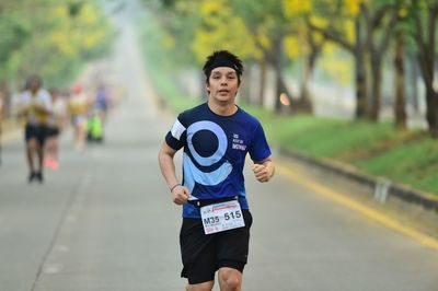 Portrait of young man running in city