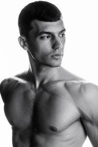 Portrait of shirtless man standing against white background