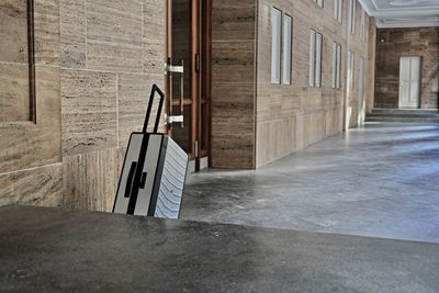 Empty chair against wall of building