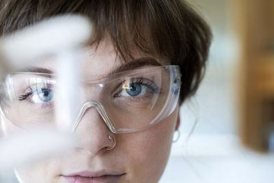 Close-up of female technician wearing eyeglasses working while standing in laboratory