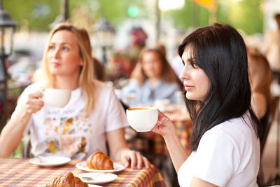 Young woman drinking coffee in cafe at restaurant