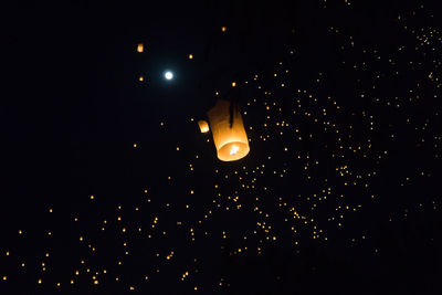 Low angle view of illuminated lantern against sky at night