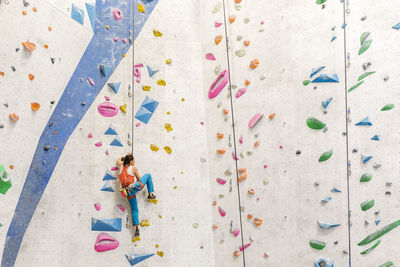 Low angle view of woman climbing on wall