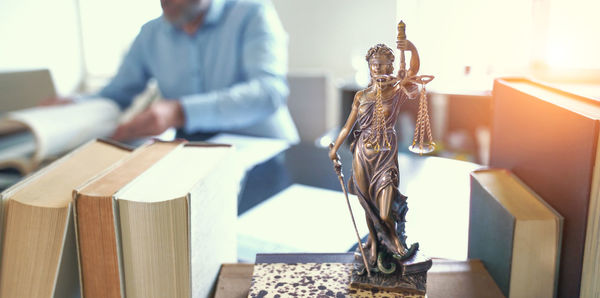 Midsection of man reading book on table