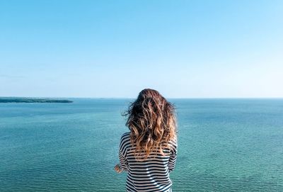 Rear view of woman looking at sea against sky