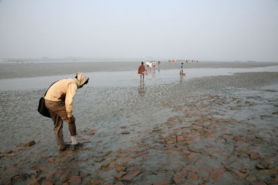 People on beach against clear sky