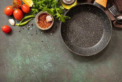 Food cooking background with frying pan. empty skillet, vegetables, spices and herbs.