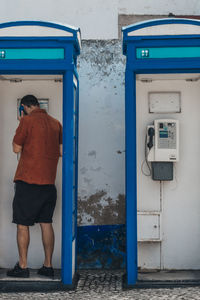 Rear view of man standing against wall