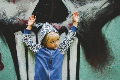 Cute girl standing against graffiti on wall 