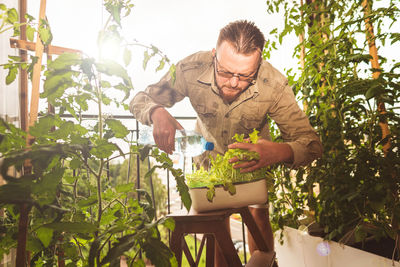 Young man standing by plants