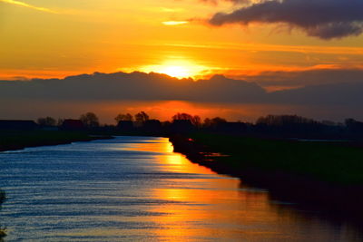 Scenic view of river against romantic sky at sunset