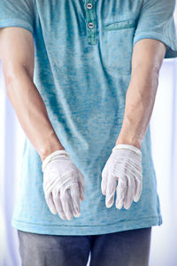 Midsection of man with surgical gloves