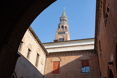 Spire of the bell tower of cremona known as torrazzo, seen from inside the courtyard cremona, italy